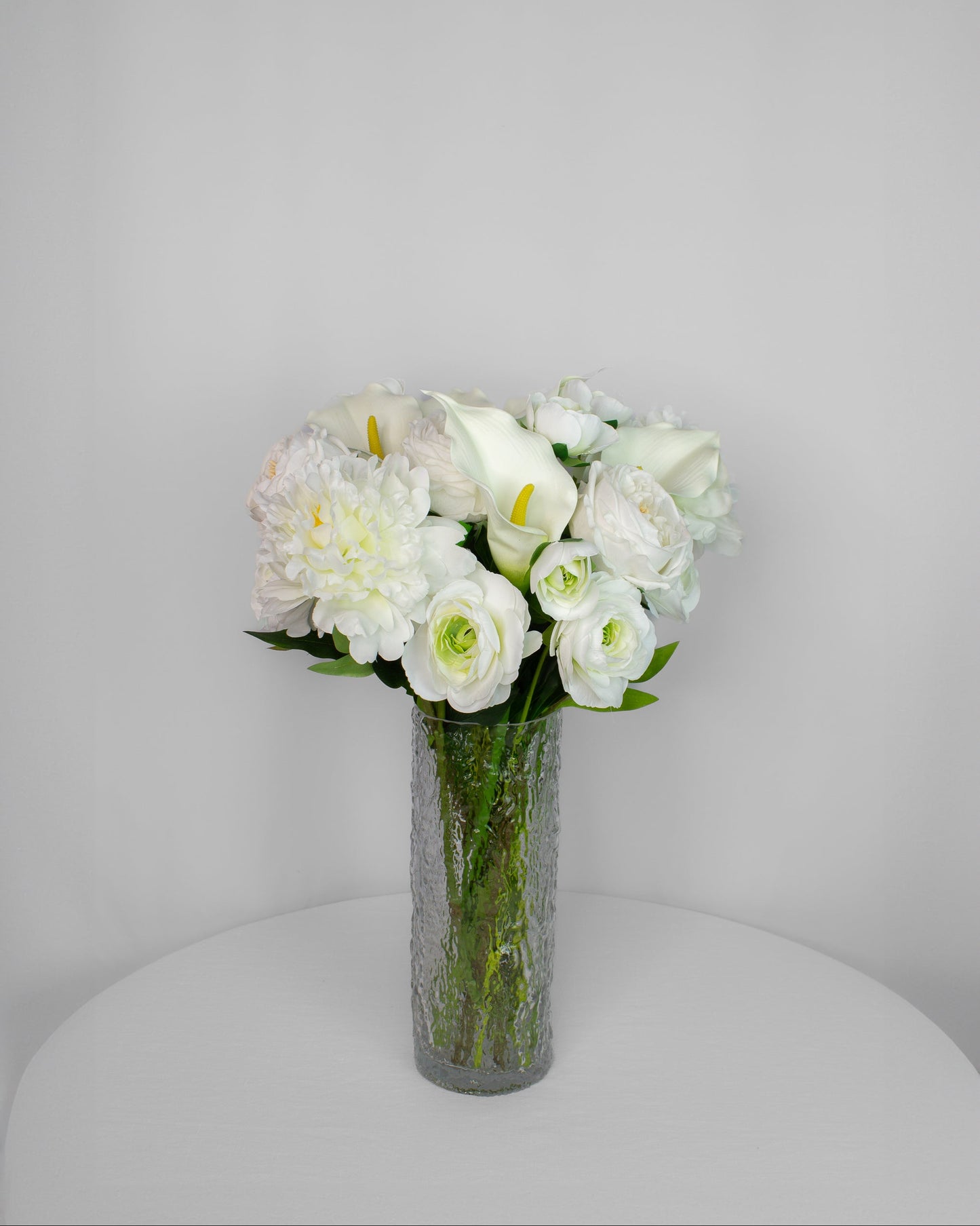 Calla Crystal naturtro kunstig buket i hvid med calla-liljer, pæoner, ranunkler og engelske haveroser i glasvase