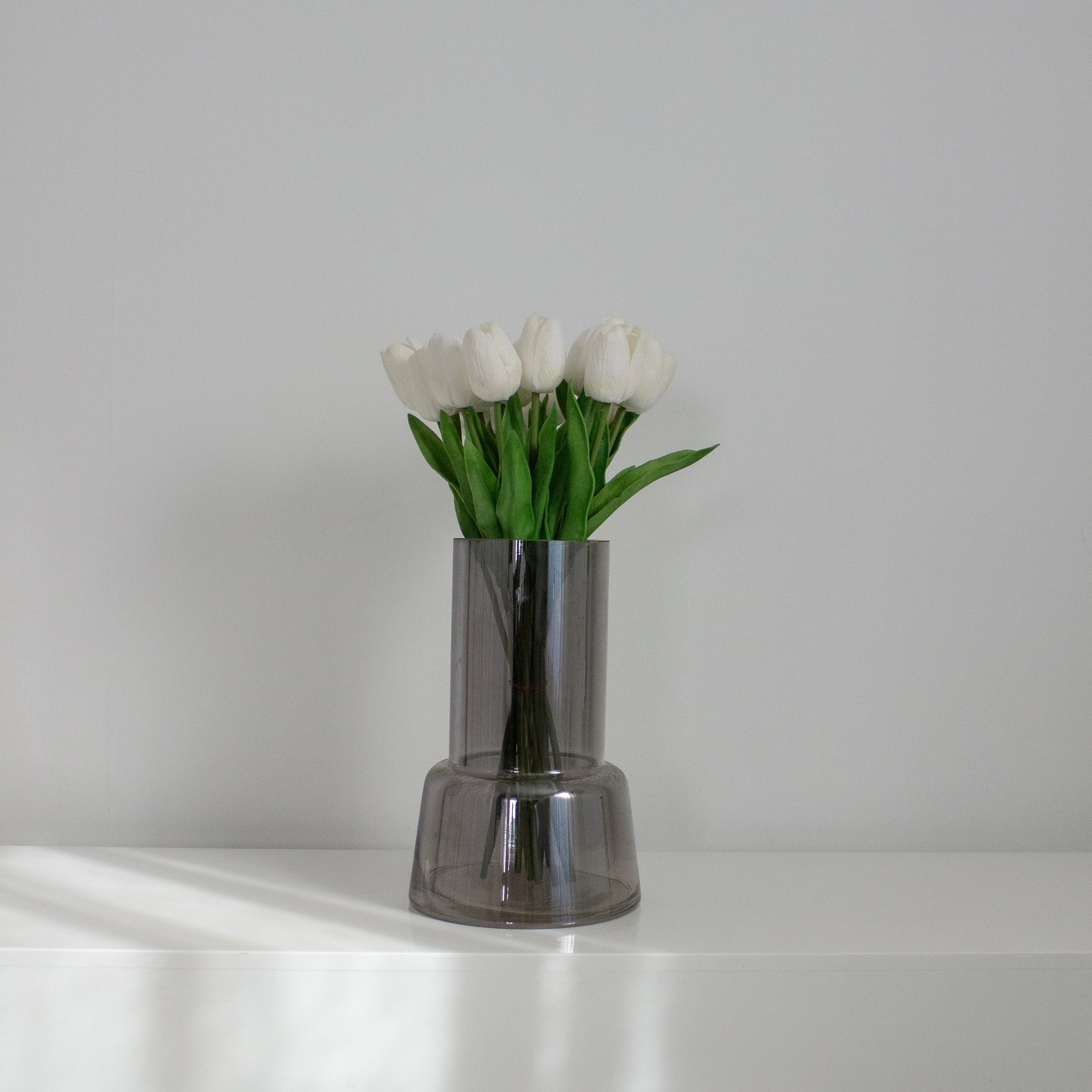 hvide tulipaner – kunstig buket i gennemsigtig vase i vindueskarm