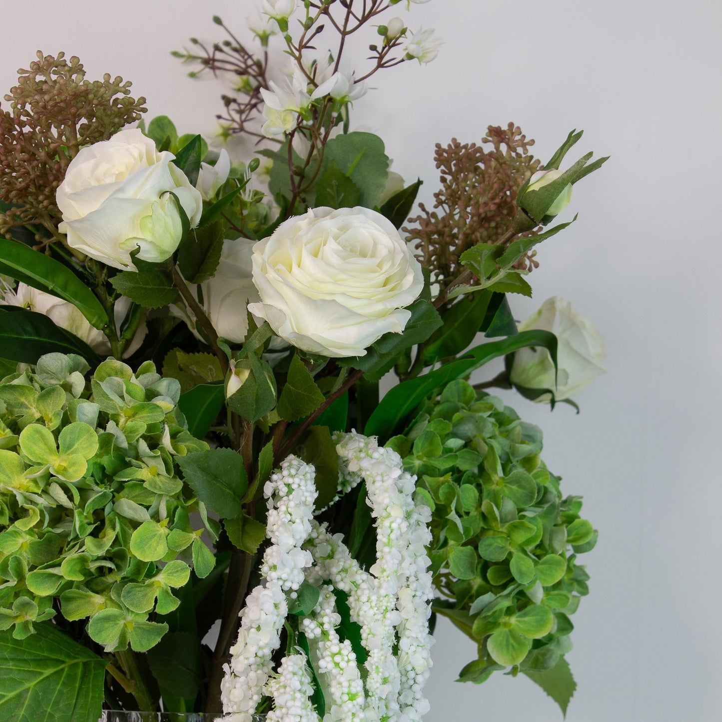 Detalje af hvide roser og skimmia-bær i Whitewood blomsterbuket