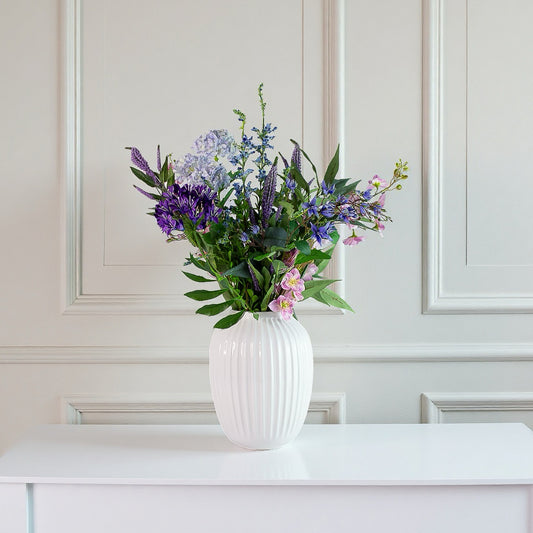 Bluebell Serenade – kunstig blå/lilla buket i hvid vase på konsol/spisebord