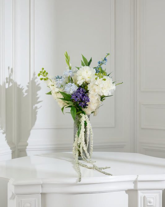 Midnight Cascade naturtro kunstig buket i hvide og blå nuancer med hængende amaranthus i glasvase