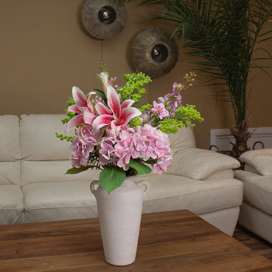 Garden Majesty buket som centerpiece på spisebord – lys, elegant indretning.