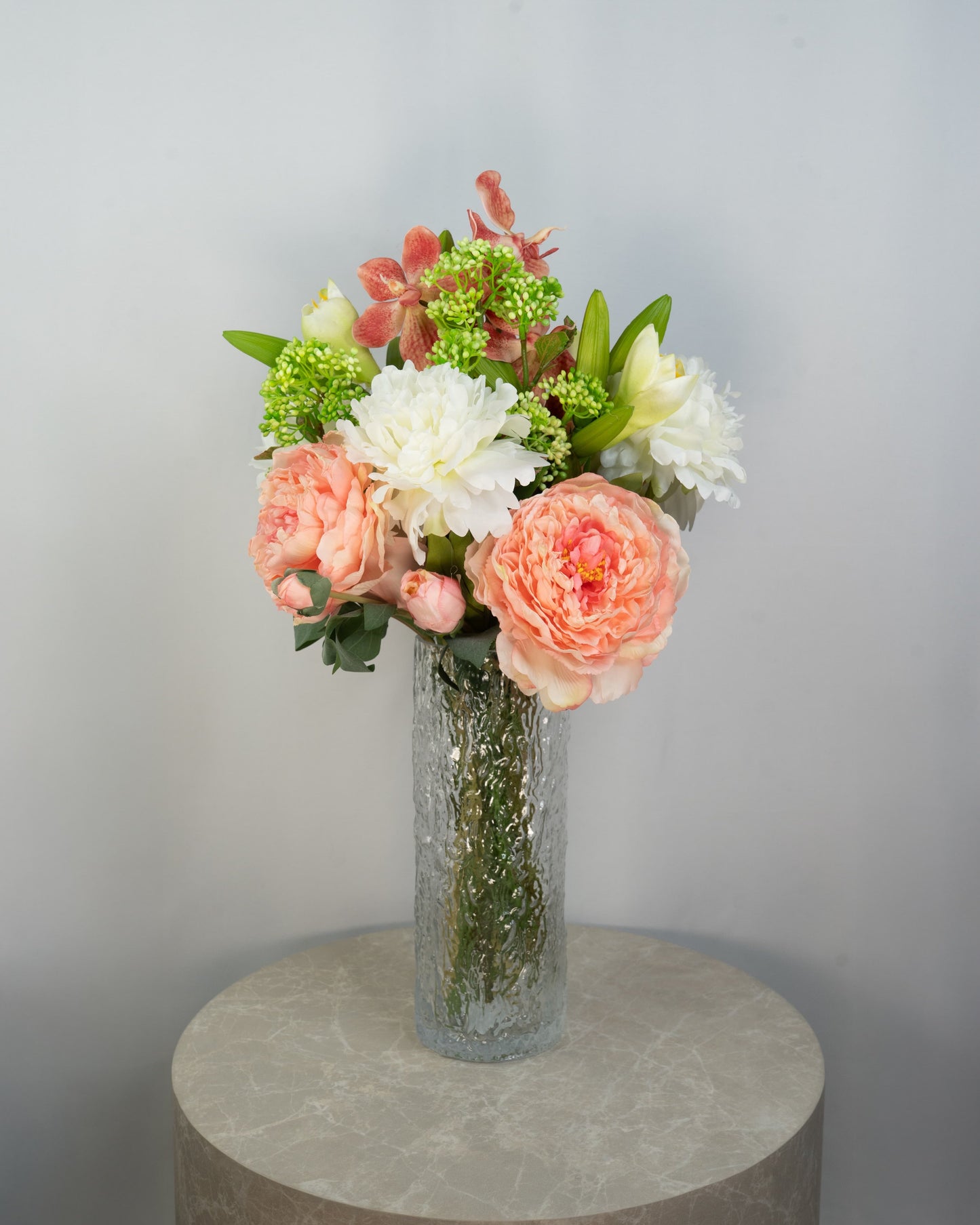 Sunrise Peony naturtro kunstig buket med coral/rosa pæon-bonderoser, hvide pæoner og grønne detaljer i glasvase