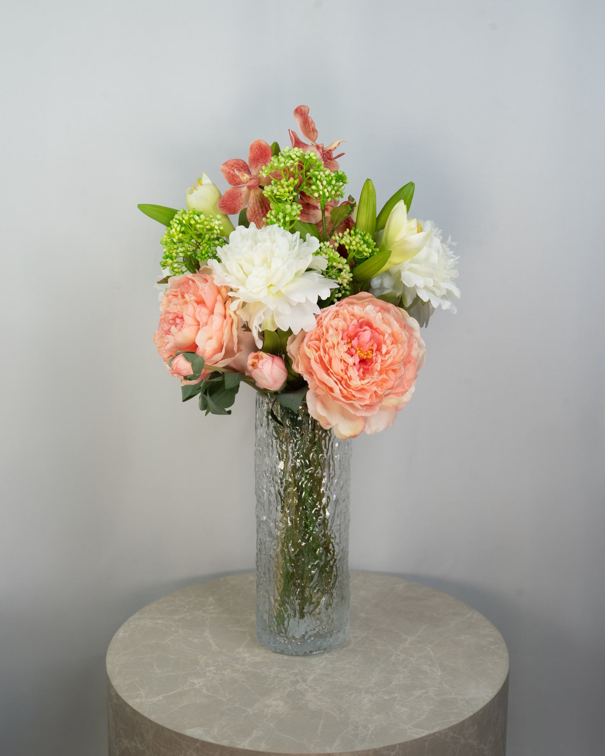 Sunrise Peony naturtro kunstig buket med coral/rosa pæon-bonderoser, hvide pæoner og grønne detaljer i glasvase